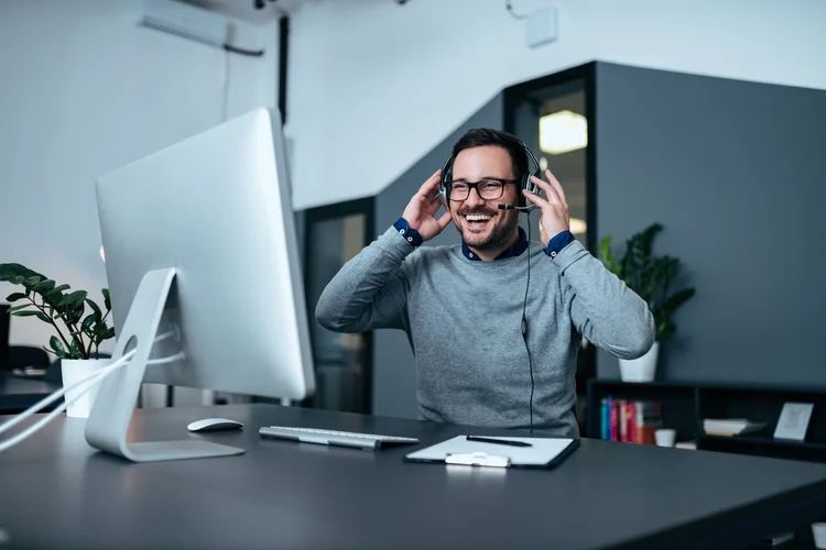 Business technology support professional wearing a headset at a desktop workstation