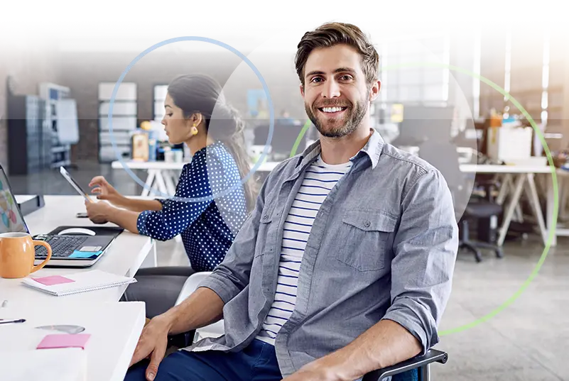 Two professionals working at computers in a modern office